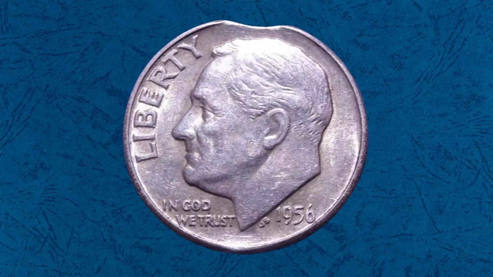 1956 Roosevelt dime clipped planchet error showing crescent-shaped piece missing from the coin edge